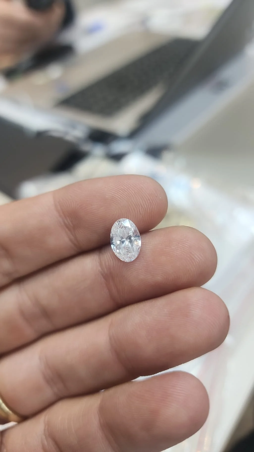 A loose oval diamond held on tweezers at the Ariek atelier